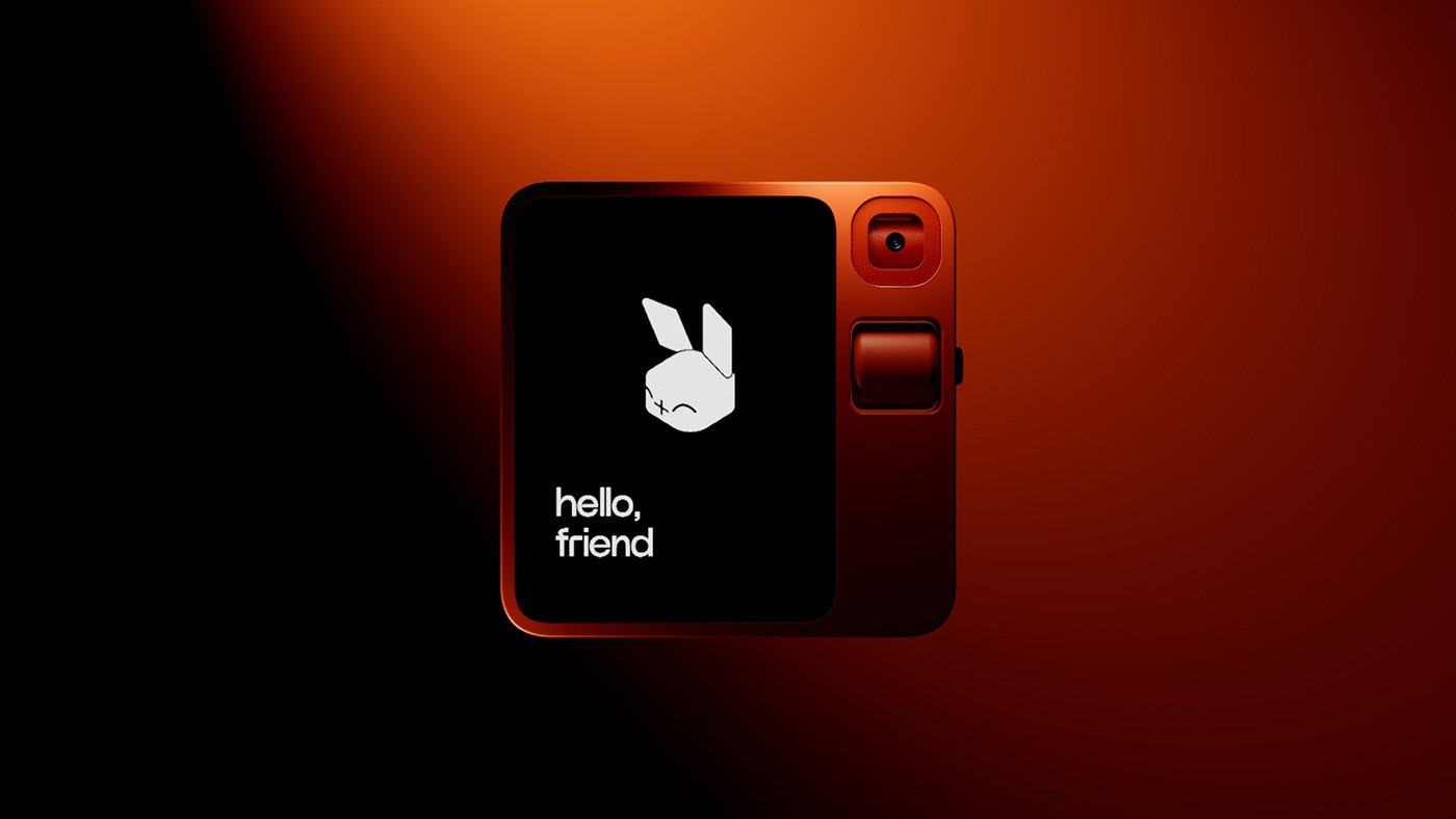 The rabbit r1, its screen reading “hello, friend”, under an orange light on black.