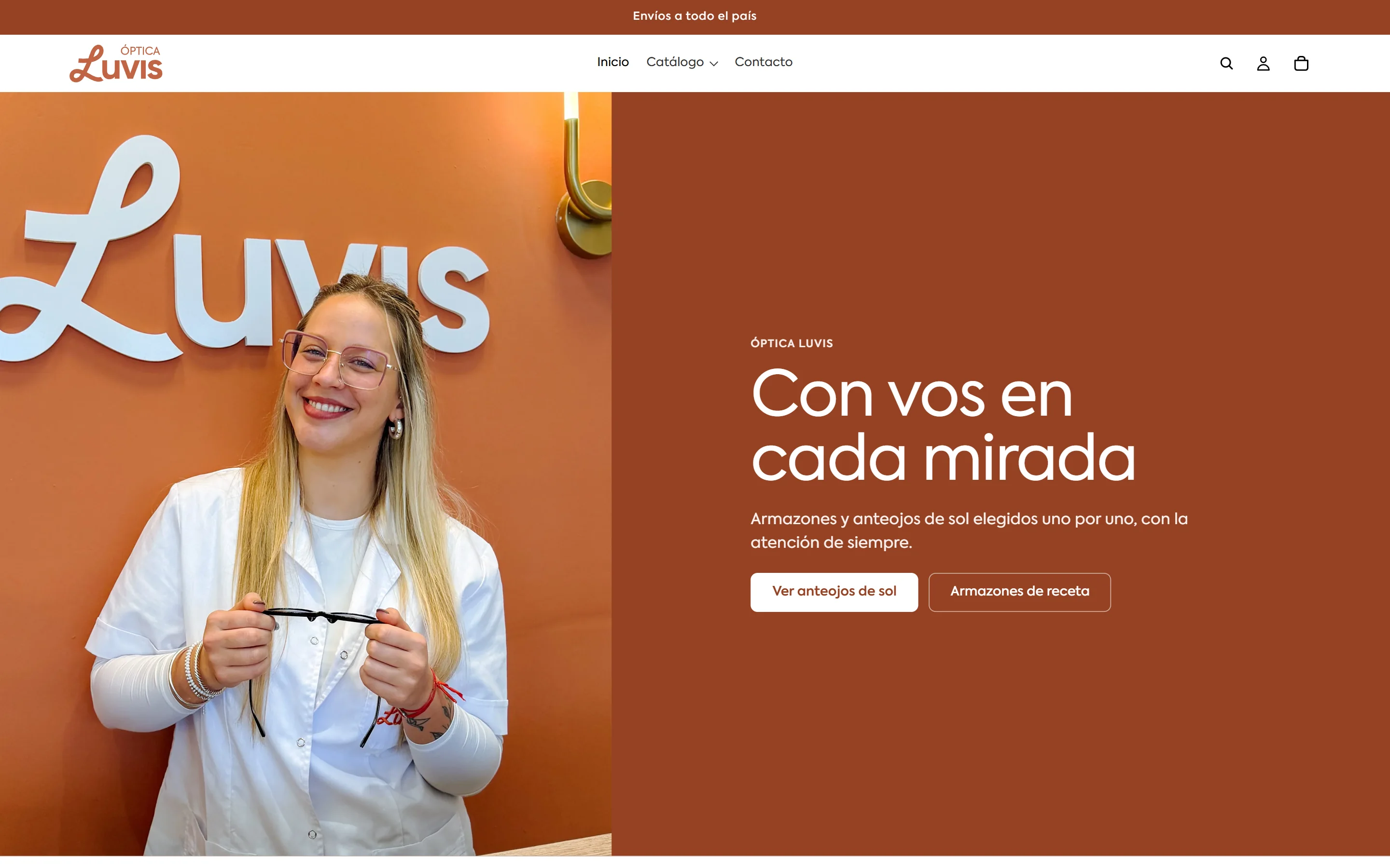 Óptica Luvis home page on desktop: a woman in a white coat holding a pair of glasses beside “Con vos en cada mirada”.