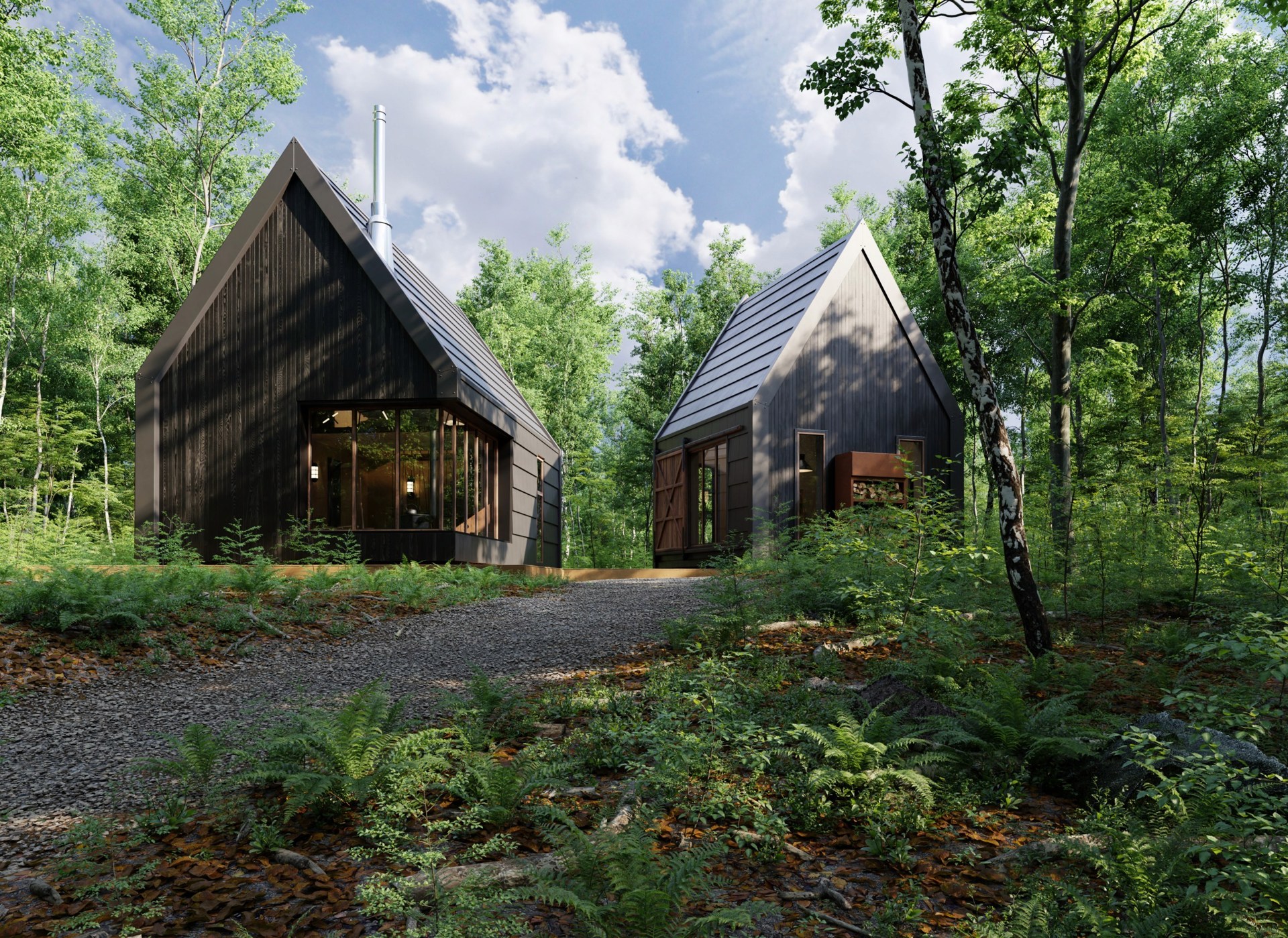 Two dark wooden cabins among trees, seen from a gravel path in daylight.
