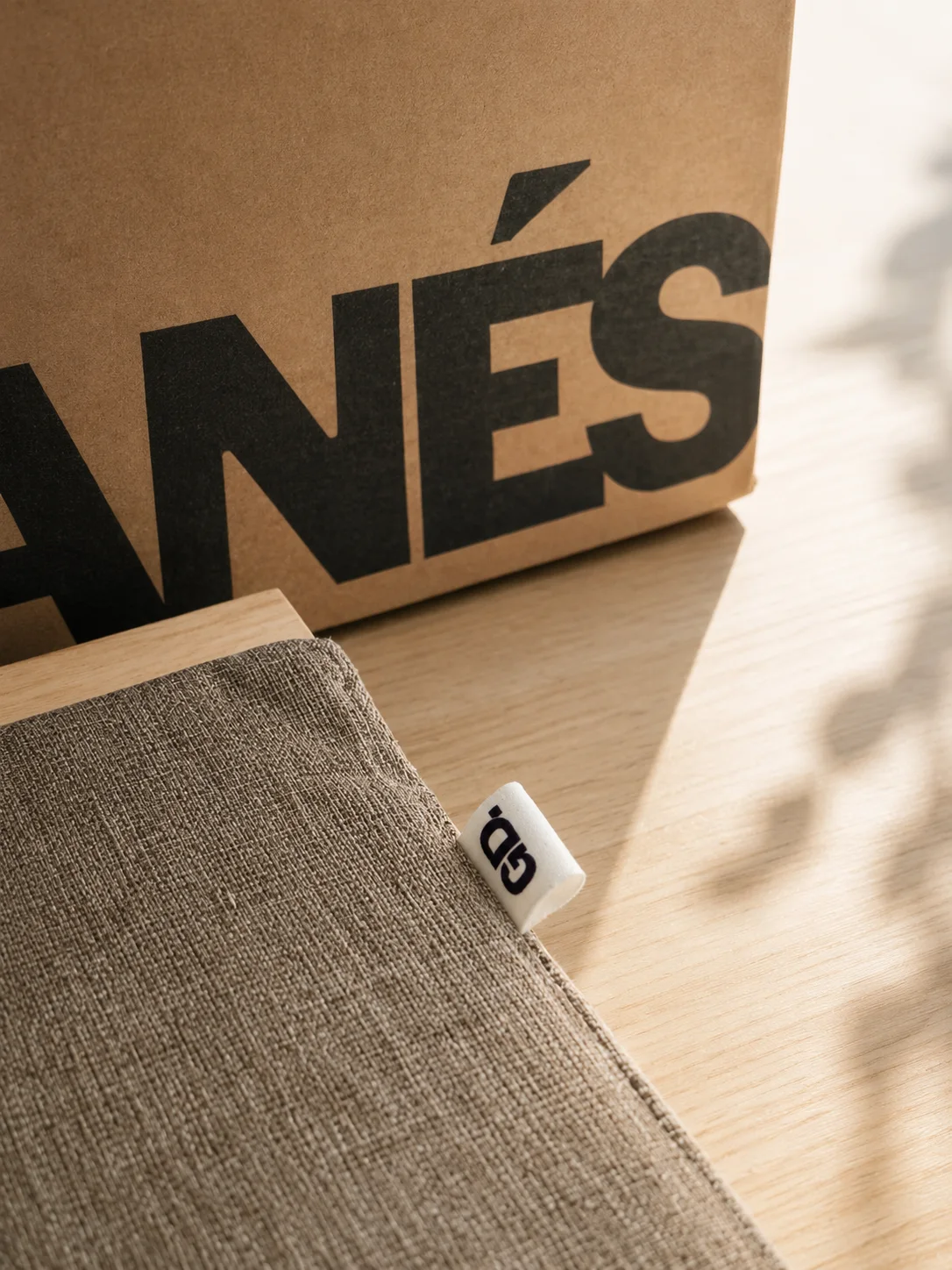 The GD tag on Vetra’s gray cushion, beside the box.